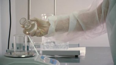 Kimyager ölçü ölçü fincan elektronik ölçeklerde içine dökme viskoz sıvı. Arka plan, sıvıları karıştırma ilaç otomatik blender.