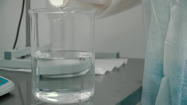 化学家将白色粉末放入带有液体的量杯中 科学家混合粉和液体为实验 — 图库视频影像