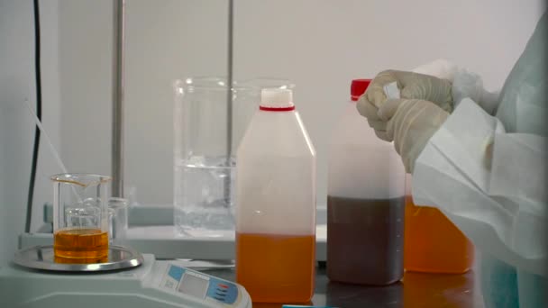 工人在秤上测量液体 它太多了 他把它放进瓶子里 制药自动化搅拌机混合液的背景 — 图库视频影像