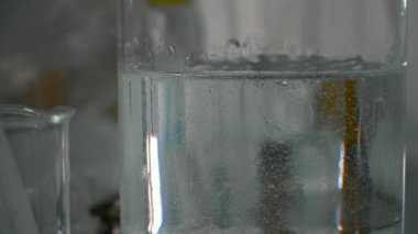 Laboratuvar cam kapsayıcısında jel. Kamera çekimde. Yakın çekim. İnsanlar bulanık arka plan çalışma.