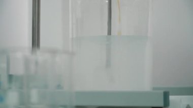 Bir cam fincan viskoz sıvı blender ile karıştırma. Bir fincan içine portakal sıvı dökme kimyager. Sıvı bir laboratuvar deneyin. Yakın çekim.