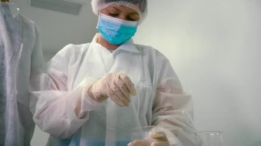 Kimyager viskoz sıvı bir balonun içinde bir cam tüp ile karıştırma. Laboratuar asistanı sürecinebakış karıştırma arıyorum. Laboratuvar çalışanları ilaç fabrikası'nda.