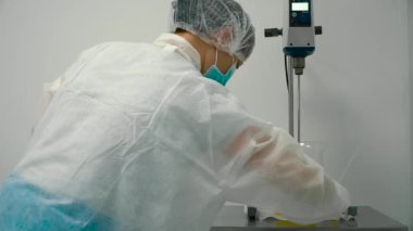 İşçi ekipman soket ile bağlayın. Kimyager laboratuvar çalışmaları için ekipman hazırlanıyor.