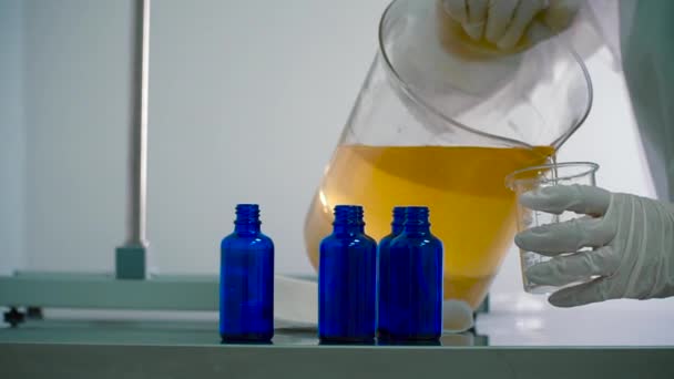 Chemik Wlać Płyn Środka Szklanki Trzy Butelki Stole Produkcji Farmaceutycznej — Wideo stockowe