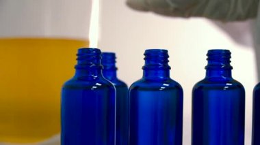 Eczacı laboratuvarında bir şişe içine sıvı dökme. İlaç fabrikası. Yakın çekim.