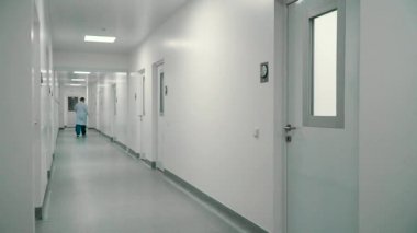 Çalışan bir hastane koridordan bir oda yürümek. Laboratuar asistanı kapıyı aç ve içeri.