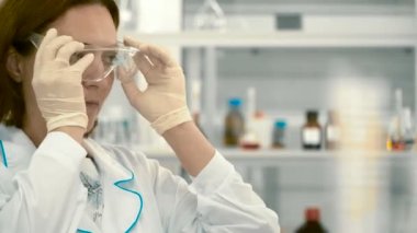 Kimyager yüzünde koruyucu gözlük koymak. Bilim adamı laboratuvar testinde hazırlanılıyor.