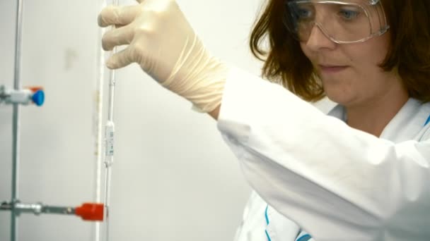 化学者は 管を通ってフラスコに酸を注ぐ 科学者を現代実験室で液体の実験します 女性の手の後 次のカメラ — ストック動画
