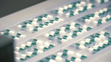İşçi sıralama kapsül paket halinde. Kapsül ile konveyör. Modern ekipman ilaç fabrikası'nda. Hap kapsül yapmak için makine. İlaç satırının üretim.