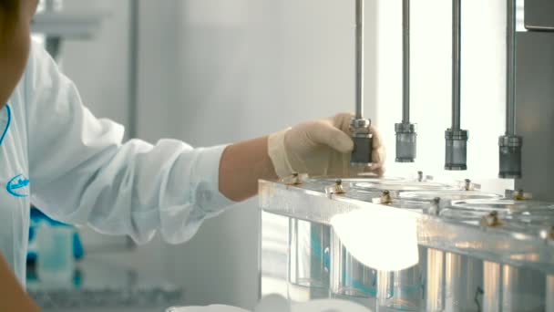 化学者は 実験装置を調整します 男のツイスト マシンに詳細 科学者の医学テストのためのコンピューターの準備 — ストック動画