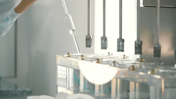 化学者は 実験装置のコンテナーからサンプルを取る コンテナー内のガラス管を保持している科学者 医薬品工場で香水のサンプルは 実験助手 — ストック動画