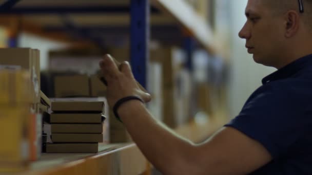 Inspecteur vérifier les colis sur les étagères dans l'entrepôt et la rédaction du rapport 