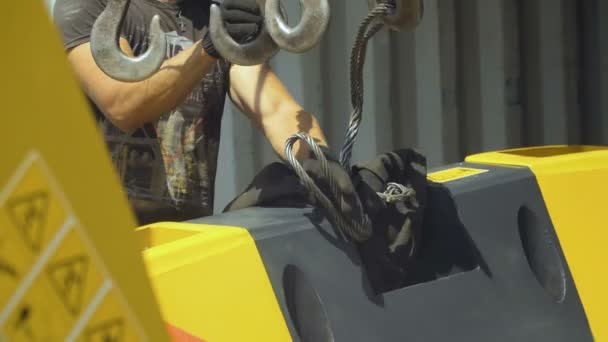 Arbeiter hakt das Detail des Traktors ein, um es zu tragen — Stockvideo
