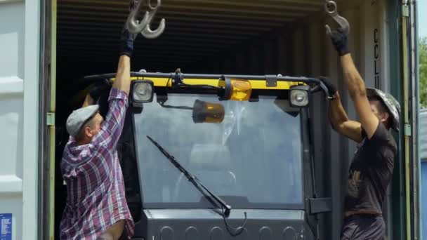 Trabalhadores conecct ganchos com máquina de agricultura para levantá-lo — Vídeo de Stock