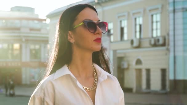 Beautiful stylish brunette in morning sun rays in slow motion at the street — Stock Video