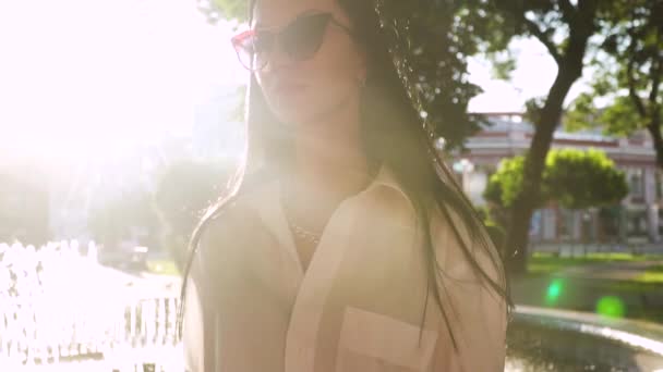 Gorgeous μελαχρινή σε γυαλιά ηλίου bask στον ήλιο ακτίνες — Αρχείο Βίντεο