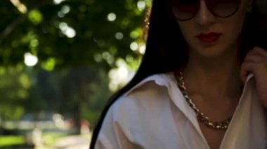 Kamera yavaş çekimde yürürken güneş gözlüğü Elegance esmer