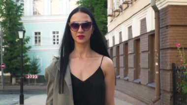 Şık ve kendine güvenen kadın kentsel Sokağı'nda, ağır çekim yürüyüş güneş gözlüğü