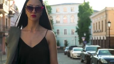 Elegance kadın moda giysiler ve ağır çekimde yürürken güneş gözlüğü