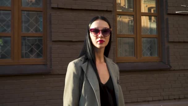 Portret van modieuze jonge brunette in zonnebrillen en stijlvolle jas — Stockvideo