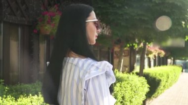 Sökülen bluz şık kadın Sokağı'nda şehir içinde küçük mağaza ile yürüyor