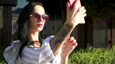 Şık esmer el dövme ile güneş gözlüğü telefonunu selfie yapmak