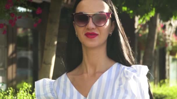 Porträtt av elegant kvinna i solglasögon och avskalade blus — Stockvideo