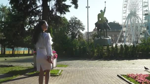 Elegante joven morena caminando en el hermoso parque de la mañana — Vídeo de stock