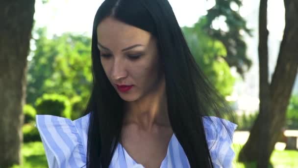 Belle brunette lire le livre dans le parc d'été — Video