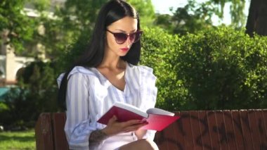 Güzel kadın güneş gözlüğü Park kitabı okuduktan