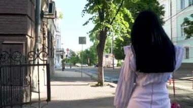 Şehir merkezinde yürüyüş telefonda konuşurken uzun saçlı esmer