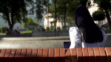 Park içinde laptop çalışan uzun saçlı Genç esmer