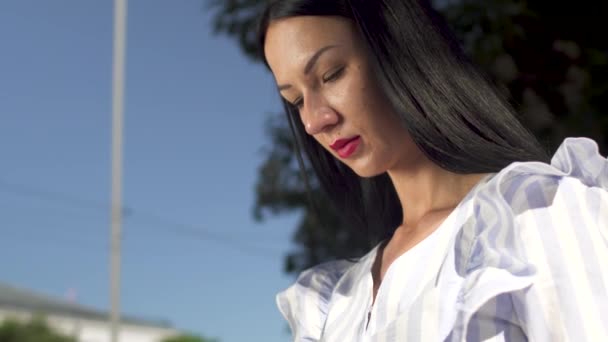 Mujer con estilo en blusa blanca respondiendo a la llamada en su teléfono — Vídeos de Stock