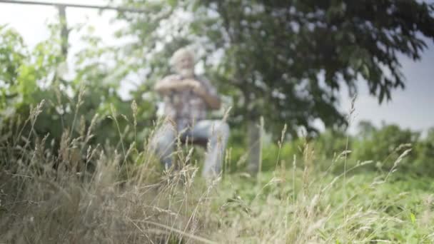 Старший мужчина отдыхает в саду — стоковое видео