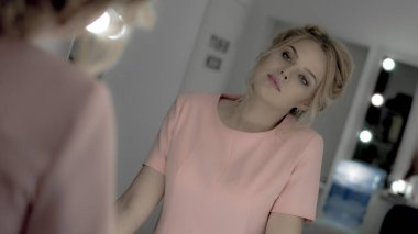 Profesyonel makyaj ve saç modeli göz ayna ile büyüleyici genç sarışın