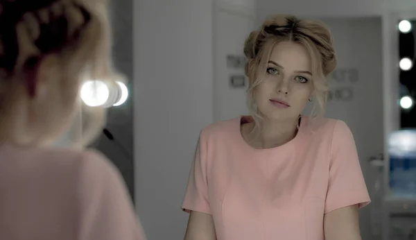 Nuori kaunis tyttö ammatillinen meikki poseeraa kameran peiliin — kuvapankkivalokuva