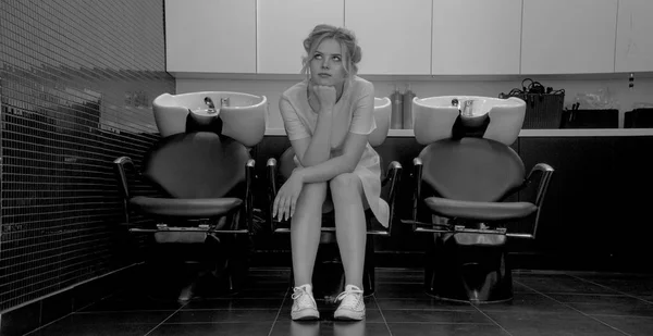 Musta ja valkoinen kuva nuori tyttö istua nojatuoli pesuallas salonki — kuvapankkivalokuva