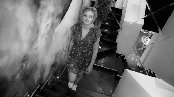 Young charming girl in dress and gumshoes stand at staircase — Stock Photo, Image