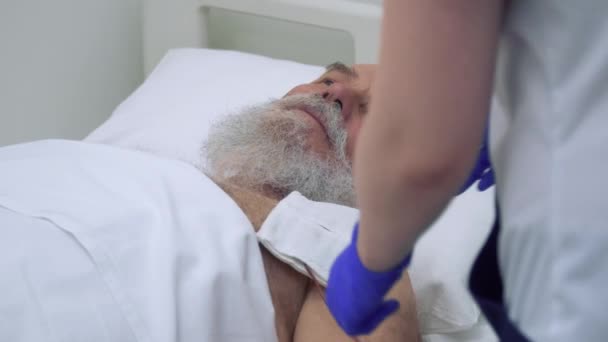 Enfermera comprobar hombre mayor durante el procedimiento de electroforesis — Vídeo de stock