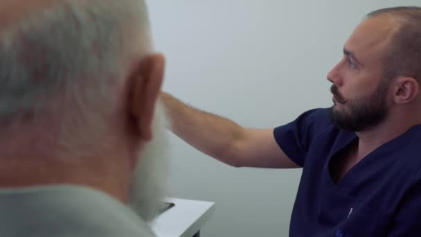 Reumatolog förklara problemet med knä på röntgen foto — Stockvideo