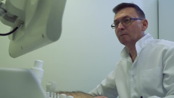 Lékař kontrolovat břicho zralý muž s ultrazvukové zařízení — Stock video