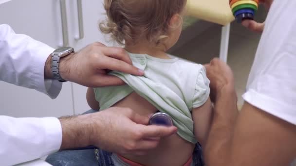 Docteur écouter en arrière de la petite fille avec stéthoscope — Video