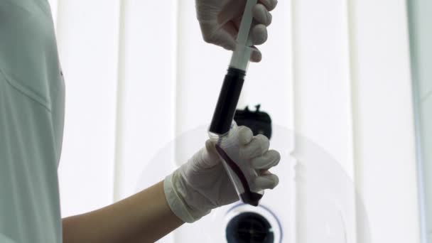 Arzt gießt Blut in eine Röhre — Stockvideo
