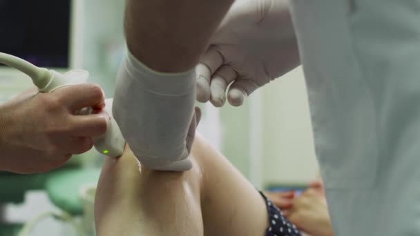 Dokter lul plasma in de knie van de patiënt het scannen met echografie apparatuur — Stockvideo