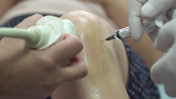 Врач укол плазмы в колено женщины и сканировать его с помощью ультразвукового оборудования — стоковое видео
