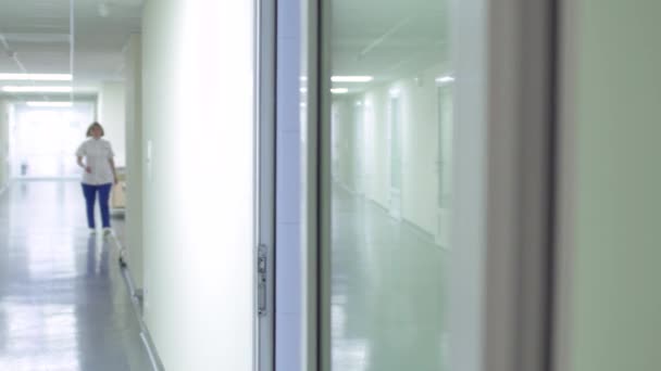 Enfermera caminando en pasillo en hospital — Vídeo de stock