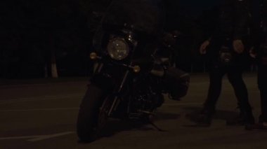 Motosiklet üzerinde oturan ve uzakta gece şehir sürme iki motorcu