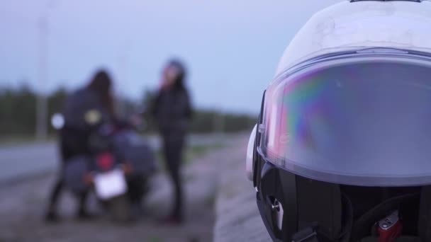 Two women bikers preparing to ride on motorcycle at blurred background — Stock Video