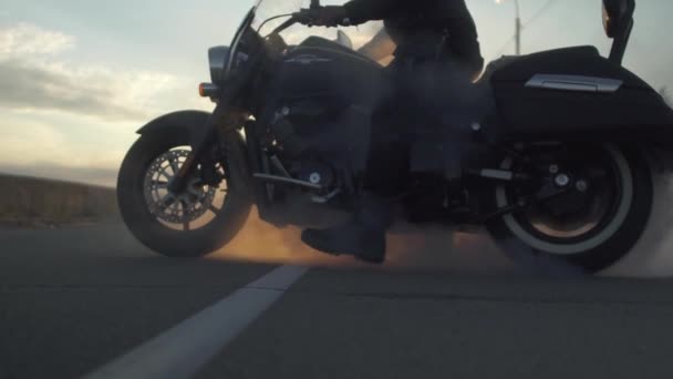 Biker tworzenia dymu z motocykla na zachód tło na drodze, w zwolnionym tempie — Wideo stockowe