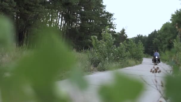 骑摩托车的人在慢动作的森林附近行驶 — 图库视频影像